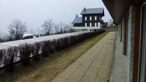 Un bâtiment avec un long chemin rectiligne menant à une entrée fermée par un portail.