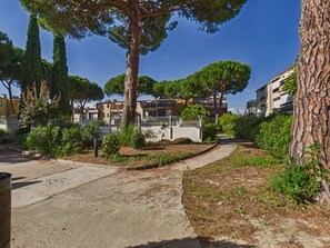 A residential area with a paved walkway, trees, and multi-story buildings. - Air-Conditioned Studio Cabin with Terrace & Pool Access in Grau d'Agde (Le Grau d'Agde)