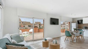 Een modern appartement met een woonkamer, een eethoek en een keuken.