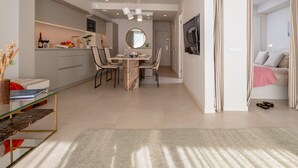 Un espace de vie moderne comprenant un coin repas, une cuisine et une chambre.