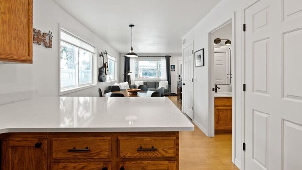 Una cocina moderna con una isla grande, armarios de madera y vistas al comedor.