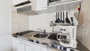 A kitchenette with a microwave, stove, sink, and a coffee maker. - Cozy Studio Apartment with Pool Access near Beach in Marseillan, Sleeps 4 (Marseillan-Plage)