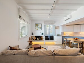 A modern living room with a sofa, a fireplace, and a television.