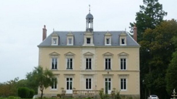 A large, stately building with a symmetrical facade, multiple windows, and a prominent central tower.