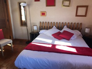 A neatly made bed with white and red bedding, a bedside lamp, and a chair with a red cushion. - Charming Country Guesthouse with Pool near Solesmes Abbey (Solesmes)