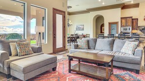 A spacious living room with a large sofa, a coffee table, and a patterned rug. - Las Cruces Home w/ Mountain Views & Private Pool! (Las Cruces)