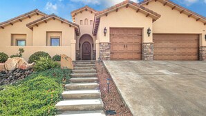 A two-story house with a front entrance, a garage, and a landscaped driveway. - Las Cruces Home w/ Mountain Views & Private Pool! (Las Cruces)