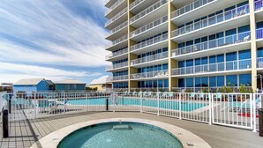 A hotel with a pool, multiple balconies, and a rooftop deck. - Gulf Shores Beachfront Condo w/ Community Pool! (Gulf Shores)