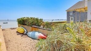 A beach with kayaks and a house with a covered porch. - Walk to Commercial Street! Couples Retreat w/ Deck (Provincetown)