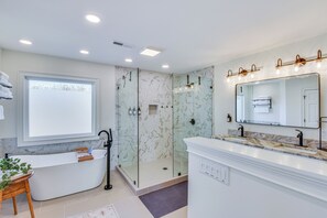 A modern bathroom with a freestanding bathtub, a glass-enclosed shower, and a vanity with a large mirror. - Lake Hartwell Home w/ Dock + Fire Pit! (Townville)