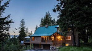 A log cabin with a green roof, multiple windows, and a garage. - Wyoming Cabin w/ Hot Tub & Mountain-view Deck (Thayne)