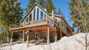 A log cabin with a balcony, surrounded by snow and trees. - Wyoming Cabin w/ Hot Tub & Mountain-view Deck (Thayne)