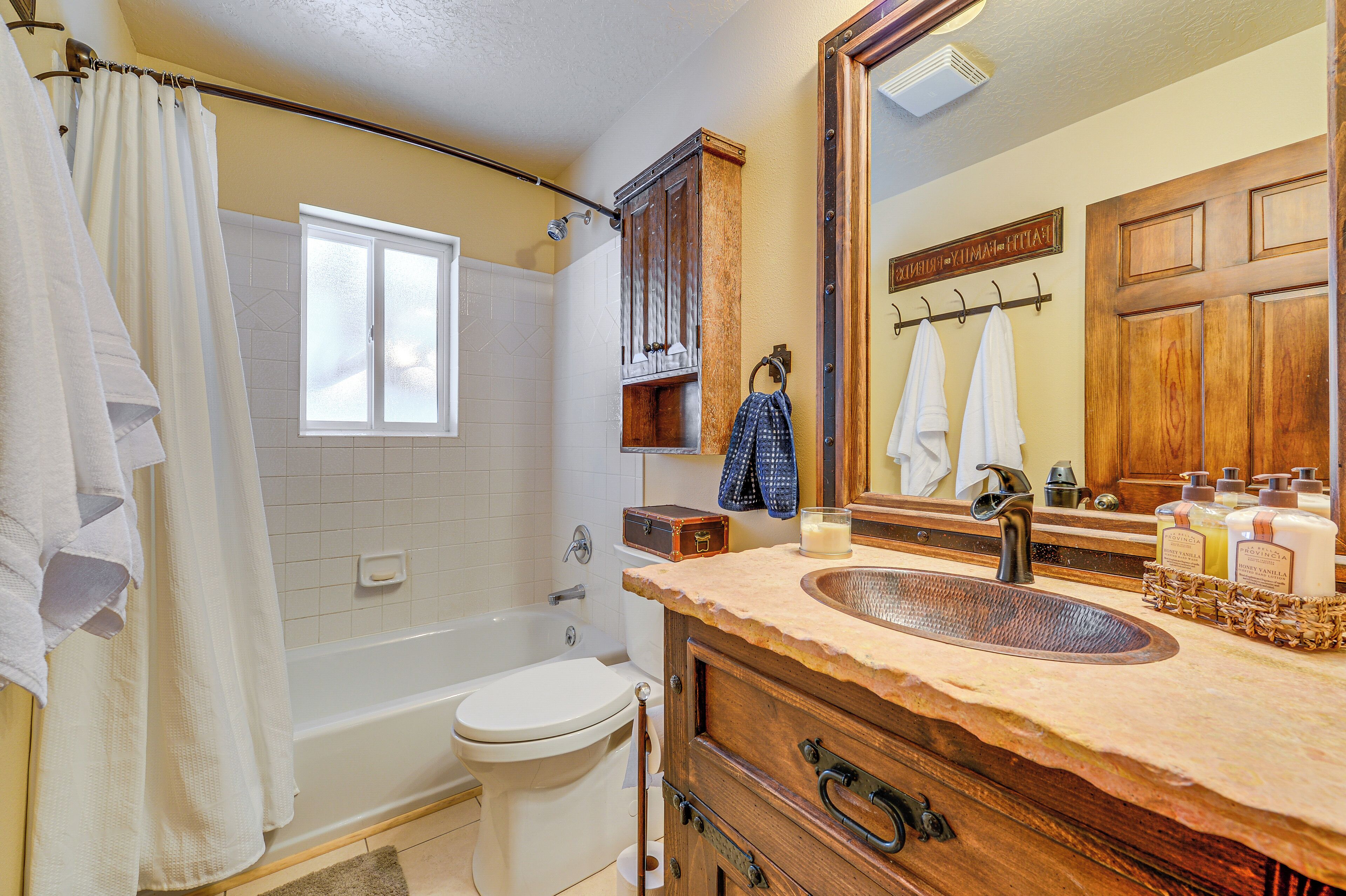 Een badkamer met een badkuip, toilet en wastafel.