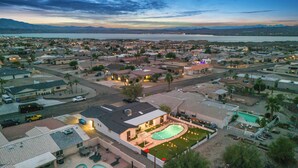 A residential area with a large swimming pool, houses, and a view of a body of water. - Sunny Arizona Oasis w/ Views - 2 Mi to Lake Havasu (Lake Havasu City)