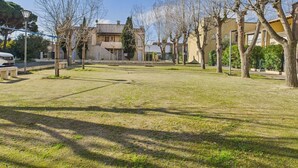 A residential area with a grassy courtyard, trees, and houses.