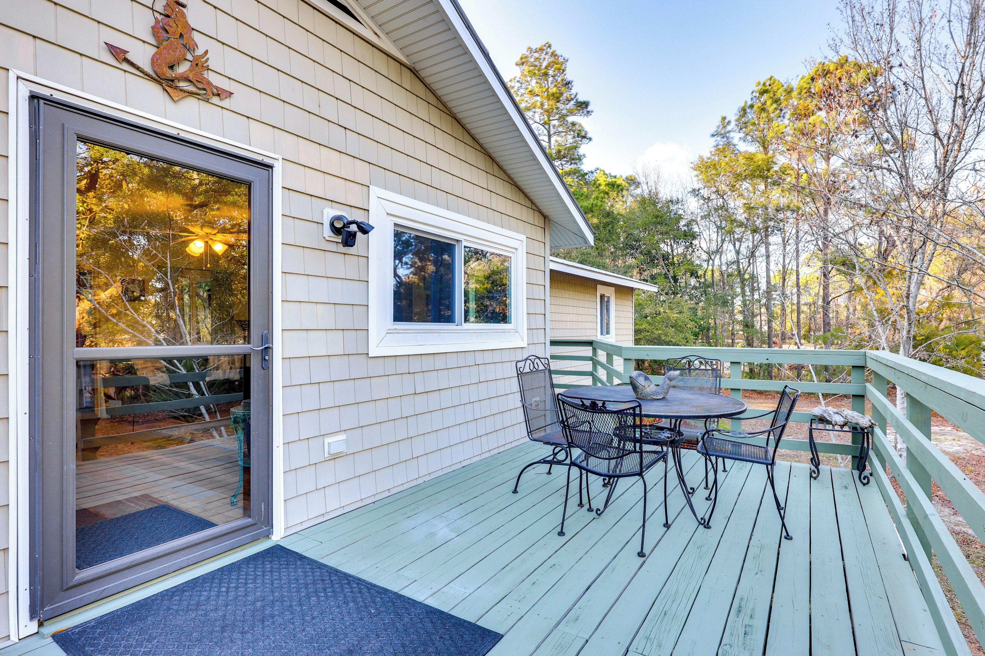 A wooden deck with outdoor furniture and a glass door entrance.