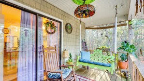 A covered porch with a rocking chair, a green bench, and potted plants. - Wilmington Getaway Near Carolina Beach Boardwalk! (Wilmington)