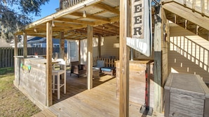 A wooden deck with a bar area, outdoor seating, and a staircase leading to an upper level. - Inviting Savannah Vacation Rental w/ Game Room! (Savannah)