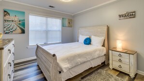 A bedroom with a bed, a nightstand, a dresser, a window with blinds, and wall art. - Inviting Savannah Vacation Rental w/ Game Room! (Savannah)