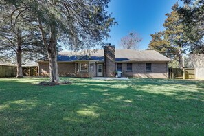 A single-story brick house with a front porch, a chimney, and a well-maintained lawn. - Lovely Decatur Home w/ Yard ~ 6 Mi to Town! (Decatur)