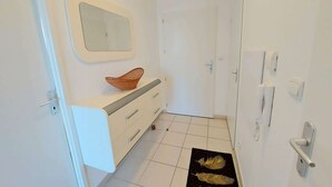 A bathroom with a white vanity, a mirror, and a door with a handle. - Beachfront 2-Room Apartment with Direct Access, Pool, and Private Parking (Marseillan-Plage)