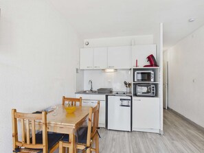 A compact kitchen with white cabinets, a microwave, a toaster, and a small sink.