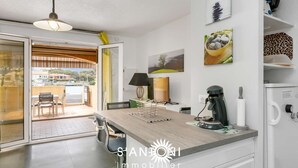 Une cuisine moderne avec un plan de travail en bois, une machine à café et une vue sur l’extérieur.