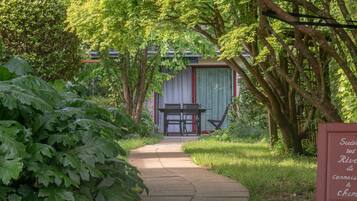 Un chemin menant à un bâtiment doté d’un espace extérieur abrité avec des sièges.