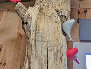 Una viga de madera con un objeto rojo y blanco adherido.