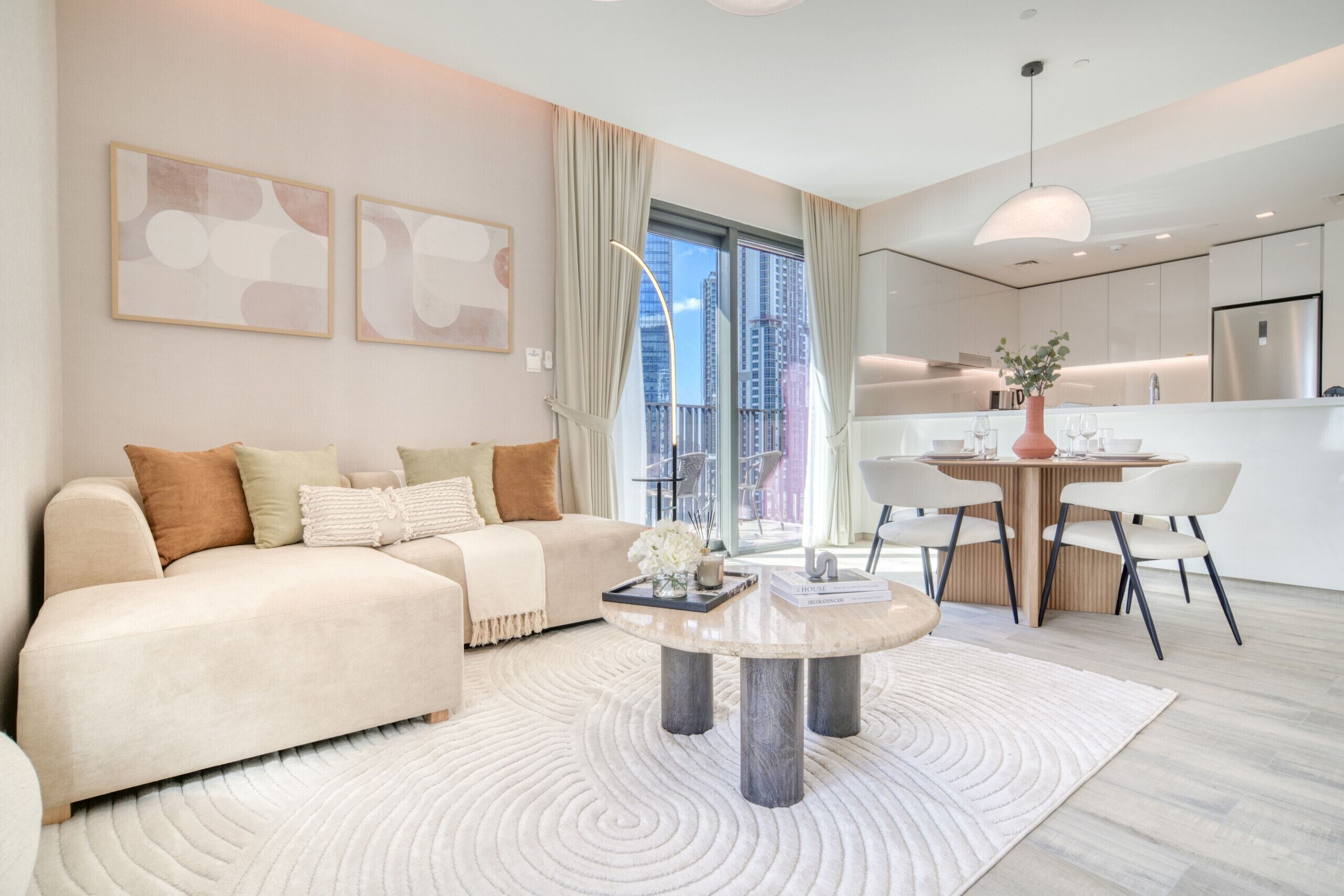 Ein modernes Wohnzimmer mit Sofa, Couchtisch und Essbereich mit Stühlen.