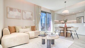 Un salon moderne comprenant un canapé, une table basse et un coin repas avec une table et des chaises.