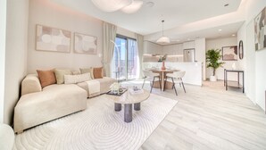Un salon moderne avec un canapé, une table basse et un coin repas.
