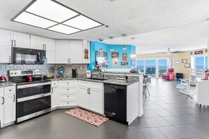 Eine moderne Küche mit weißen Schränken, einem Backofen, einer Mikrowelle und einem Geschirrspüler.