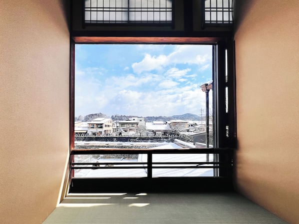 A room with a large window overlooking a snowy landscape and buildings.