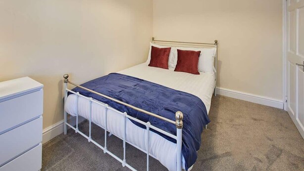 Un dormitorio con cama, mesita de noche y armario.