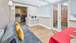 A compact living space with a kitchenette, a dining area, and a seating area with a sofa and table. - Host & Stay | Fifth Avenue (York)