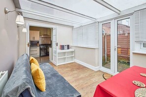 A compact living space with a kitchenette, a dining area, and a seating area with a sofa and table. - Host & Stay | Fifth Avenue (York)