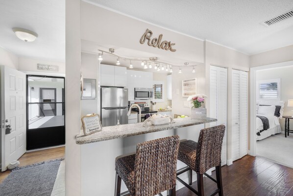 A modern kitchen with a built-in island, stainless steel appliances, and a decorative light fixture above the island.