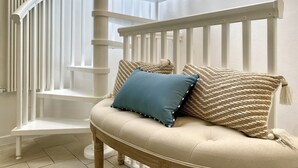 A staircase with white railings and a beige cushioned bench with two patterned cushions. - Terracielo in the heart of the historic center, suitable for couples, great location (Monopoli)