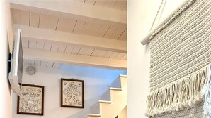 A staircase leading to a second floor, a bed with a red blanket, and a macrame wall hanging. - Terracielo in the heart of the historic center, suitable for couples, great location (Monopoli)