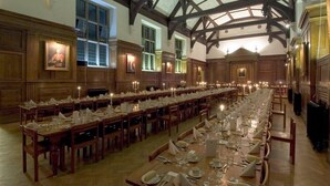 A long dining hall with wooden tables set for a meal, high ceilings with exposed beams, and large windows. - Selwyn College (Cambridge)