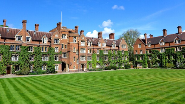 A large, historic building with multiple brick towers and ivy-covered walls, surrounded by a well-maintained lawn. - Selwyn College (Cambridge)