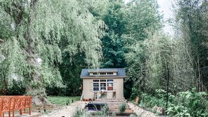 Ein kleines Haus mit Garten, umgeben von Bäumen.