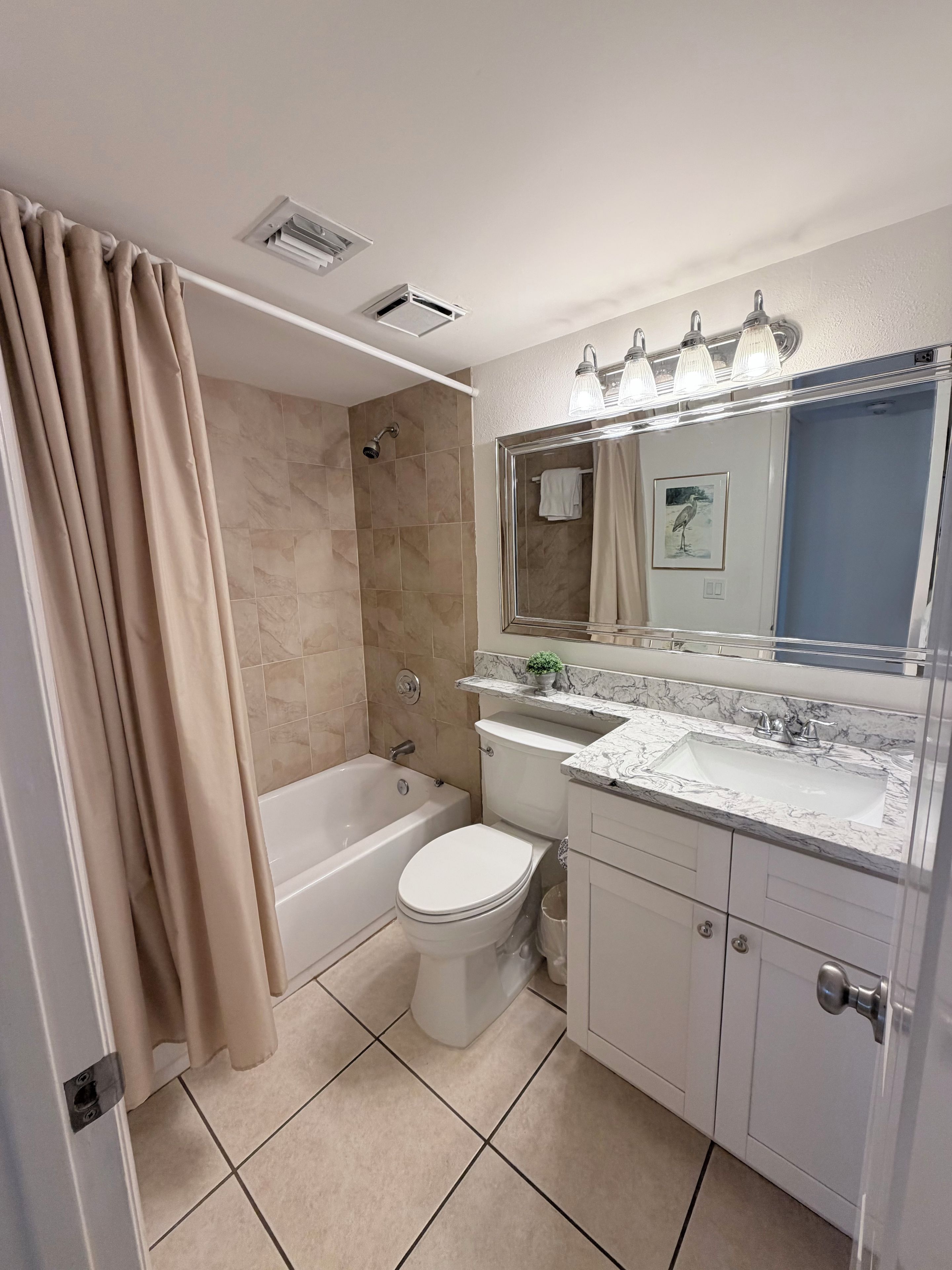 A bathroom with a bathtub, toilet, and sink.