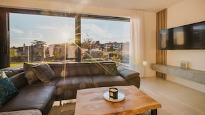 A modern living room with a leather sofa, a coffee table, and a large TV. - Beautiful Villa Angelina in Kastelir (Kastelir)