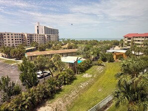 A hotel with a pool, surrounded by palm trees and a view of the ocean. - Bright and spacious 3 bedroom, 4th Floor unit (Sarasota)