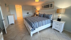 A bedroom with a bed, nightstands, a desk, a ceiling fan, and a wall-mounted lamp. - Bright and spacious 3 bedroom, 4th Floor unit (Sarasota)