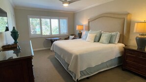 A bedroom with a bed, bedside tables, a ceiling fan, and a window with blinds. - Beachfront  2 bed/ 2 Bath Condo (Sarasota)