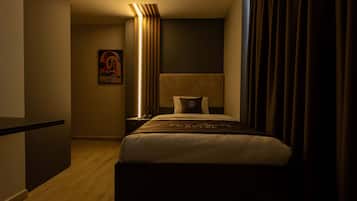 Una habitación de hotel con una cama, una mesita de noche, una lámpara y un cuadro en la pared.