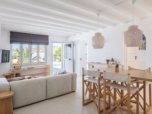 Un intérieur moderne comprenant un coin repas, un canapé et une vue sur l’extérieur.